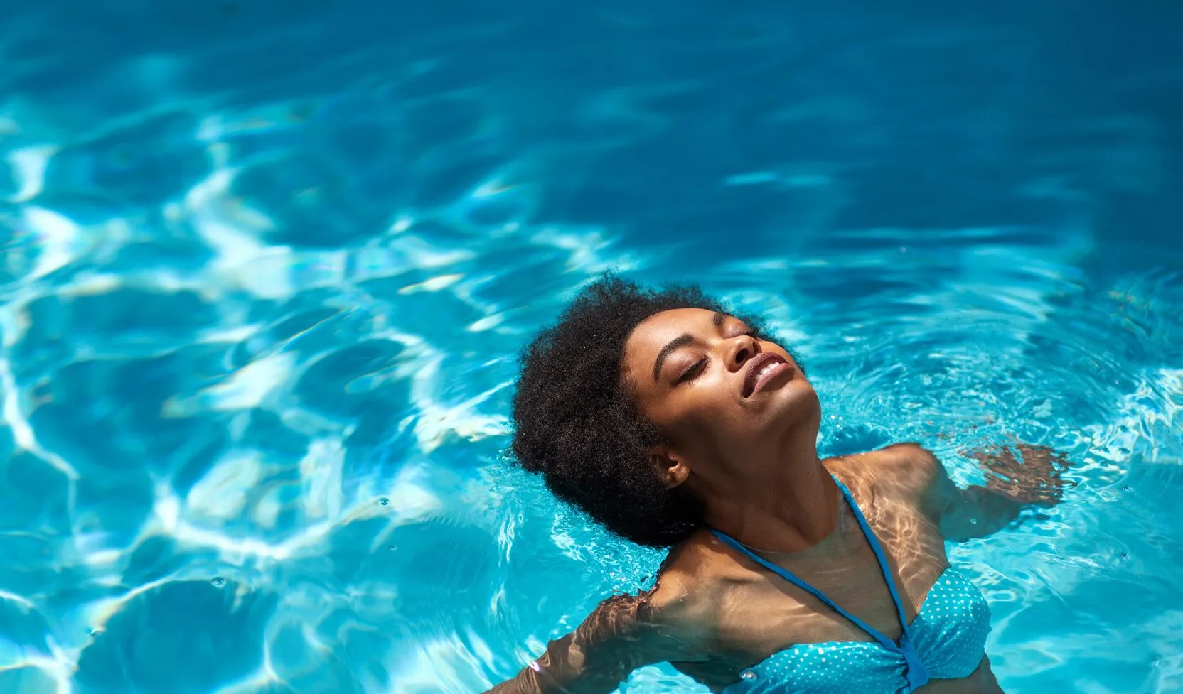 Mulher relaxando na piscina do Urban Blue View
